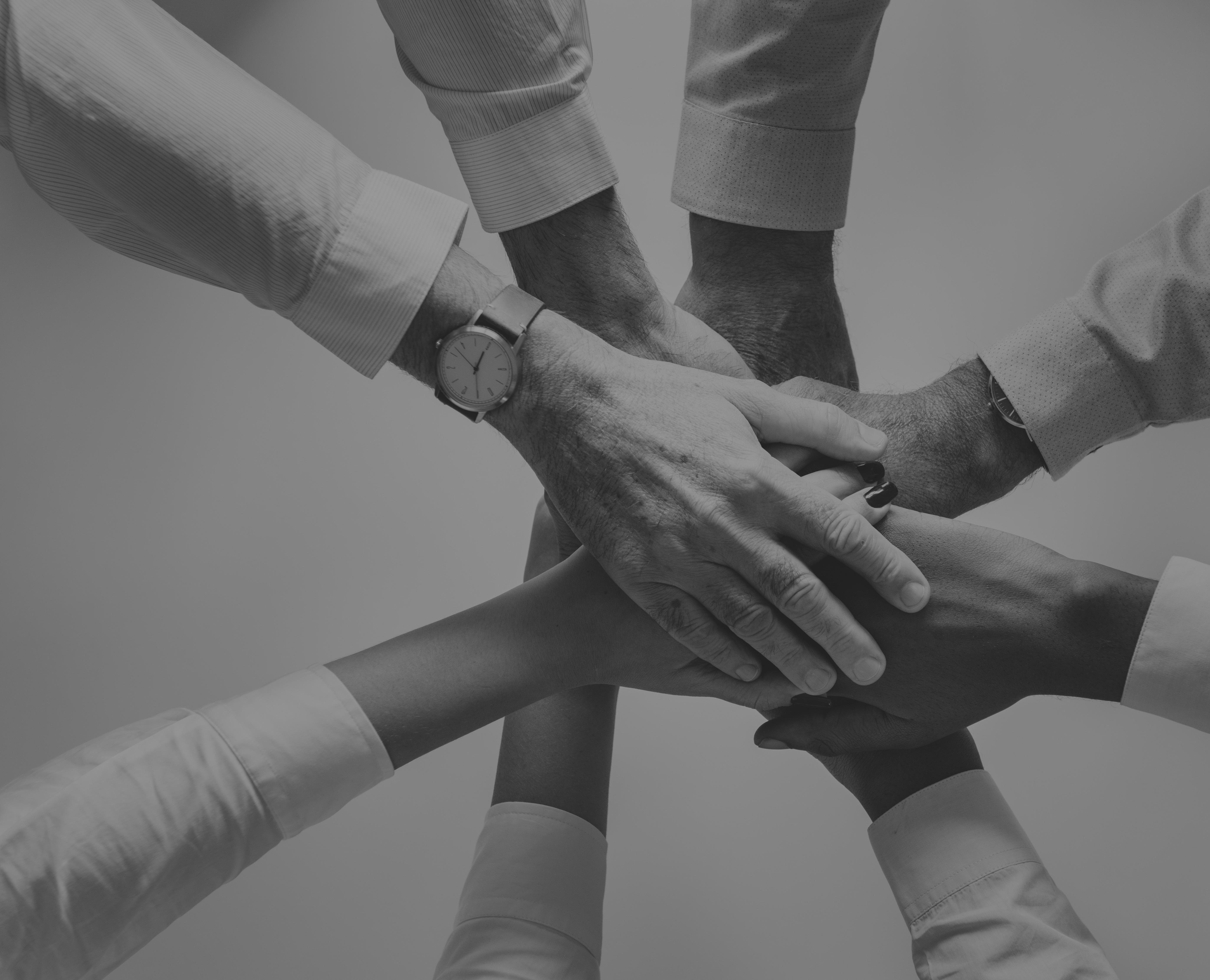 Manos de un equipo unidas en señal de compromiso.